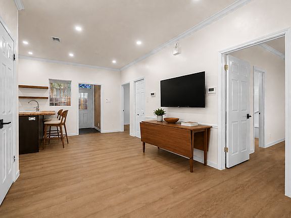 View from the living space toward the kitchen and sunroom (or flex space). Virtually staged.