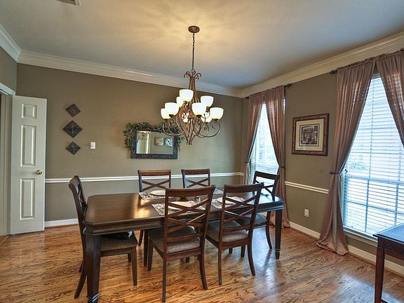 Timeless dining room with elegant light fixture and double crown plus convenient pass through to kit