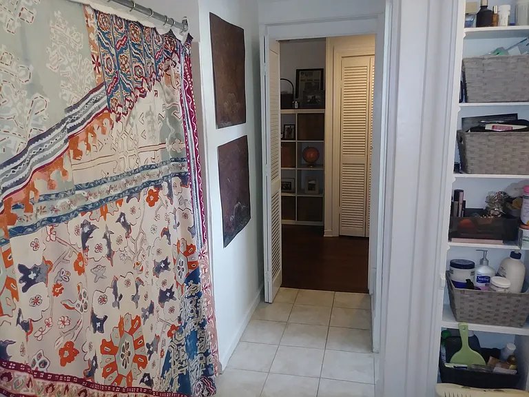 View of bathroom toward hallway, shower curtain on left is previous tenant's.