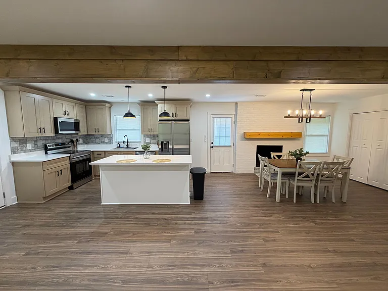 Open-concept kitchen with a large island, ample cabinetry, and stainless appliances, flowing into a dedicated dining area.