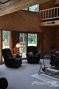 The living room area offers a valuted ceiling with windows galore,