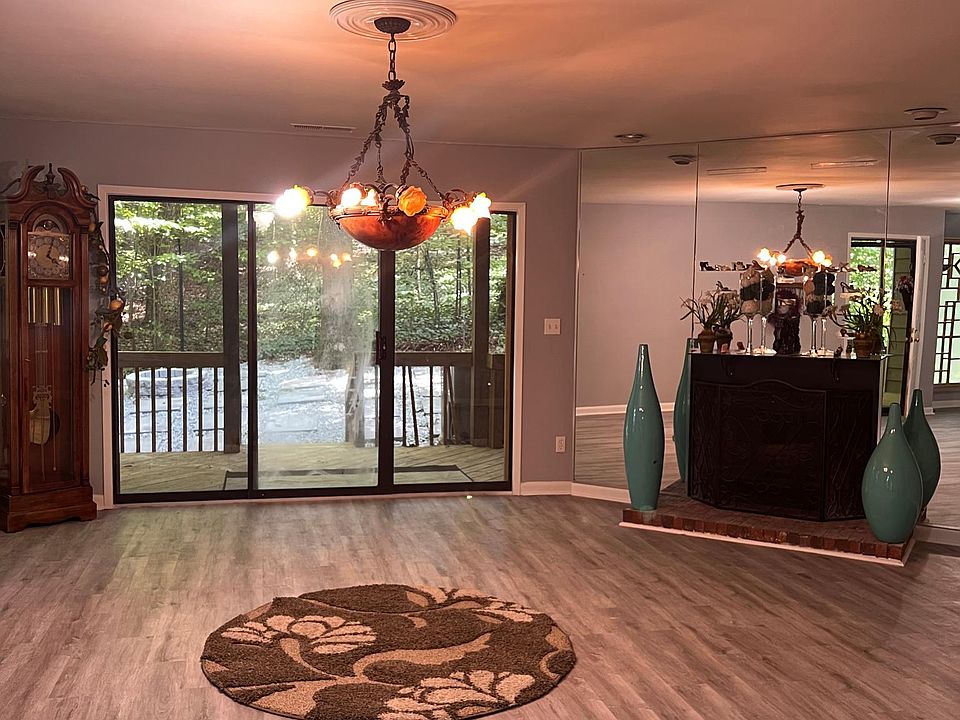 Large family room with fireplace facing to a side yard and deck