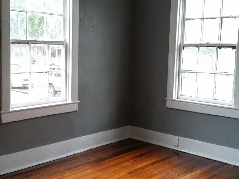 Front Bedroom - Original hardwood floors, 2" blinds, decorative fireplace, & ceiling fan with light.