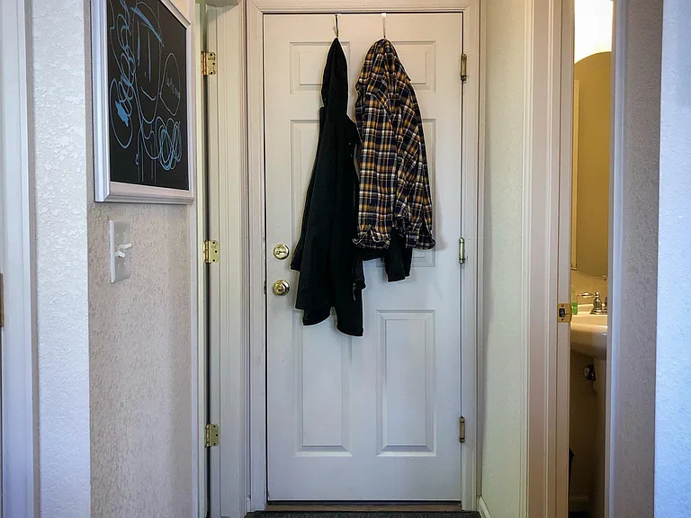 Garage door with powder room on the right and laundry room on the left