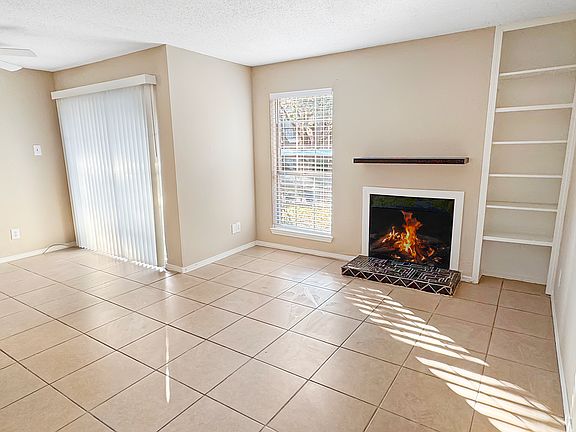 Light and bright living and dining with 2.5 in blinds and vertical blinds. Wood burning fireplace and shelving.