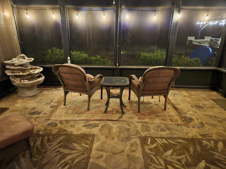 Screened porch with water feature at night
