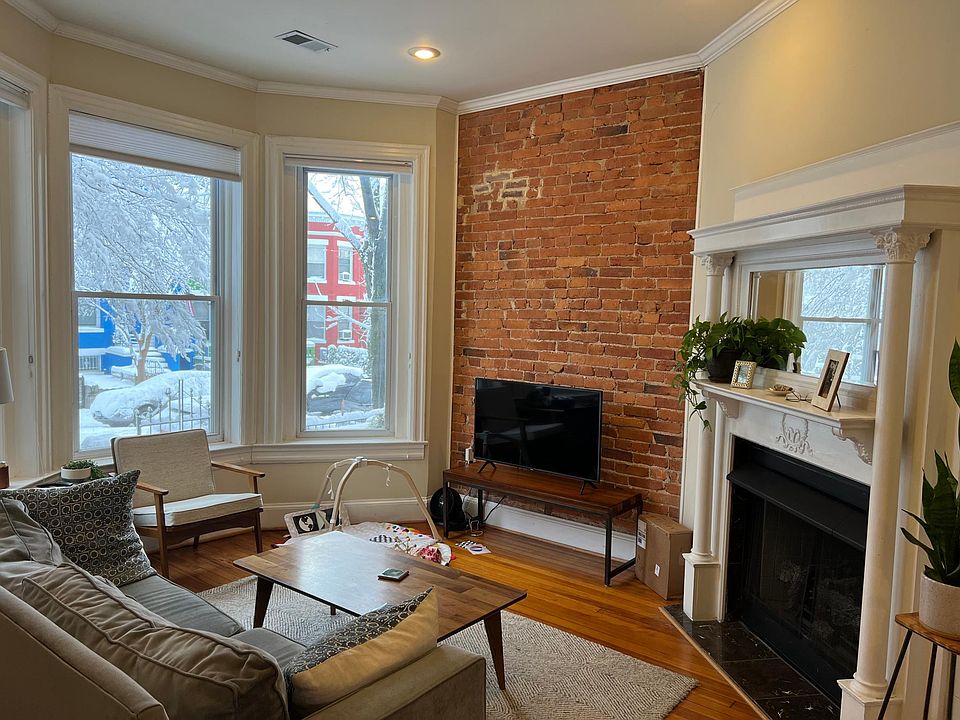 Living room. Beautiful bay windows, brick, and fireplace!