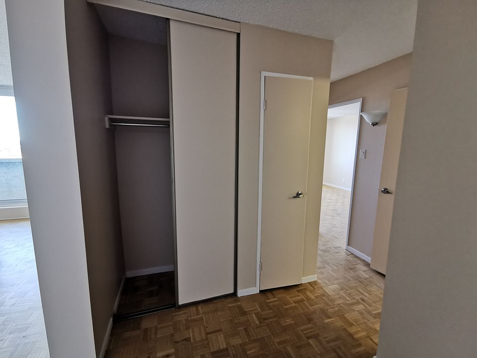 Main entrance with view towards coats closet, storage closet and bedrooms.