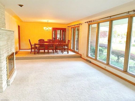 19'x15 Formal Living Room with Stone floor to Ceiling Fireplace. Wall of Windows extends to step-up Formal Dining Room (15'x11')