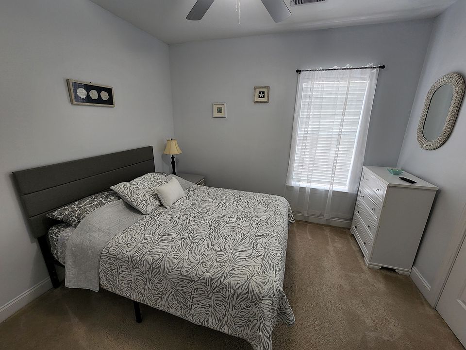 Spare bedroom with a queen size premium mattress, small dresser and a flat screen TV