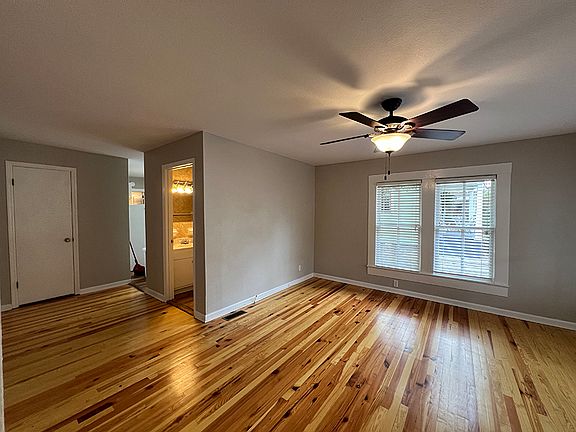 View from front door into living room, bathroom, utility closet at left with kitchen at right.