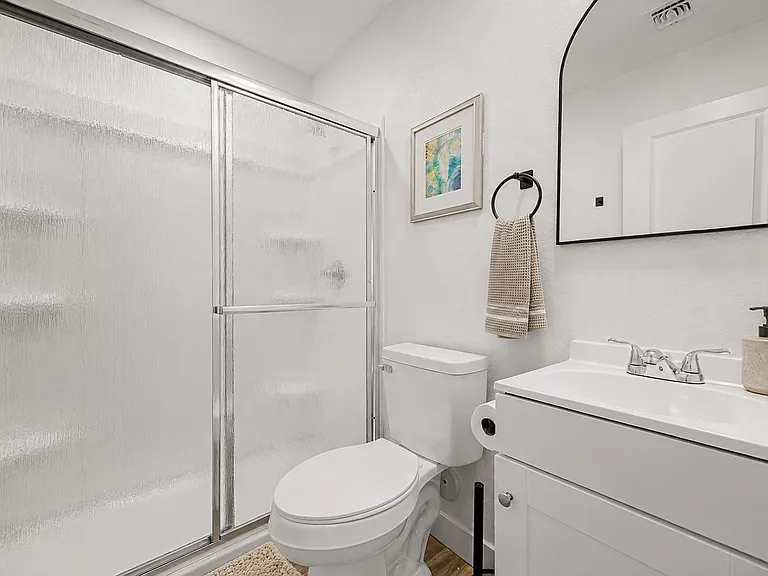 Full bathroom with walk-in shower, vanity with storage, and a large mirror for easy daily routines.