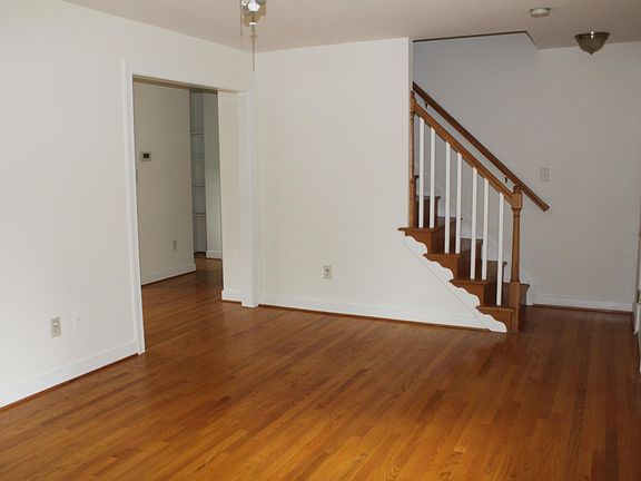 LIving room. The front door is at the bottom of the stairs on right. To the left is the dining room.