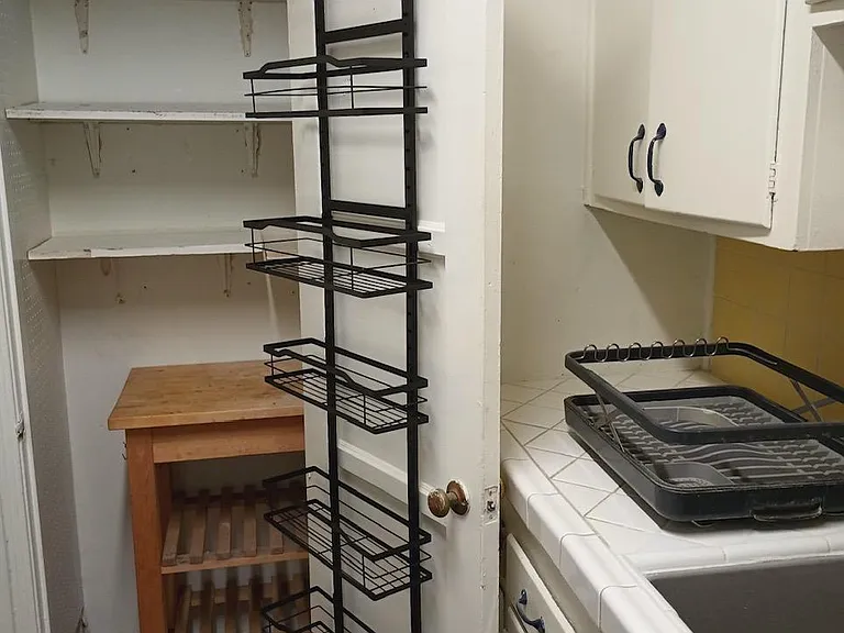 Spacious kitchen pantry with over the door storage rack.