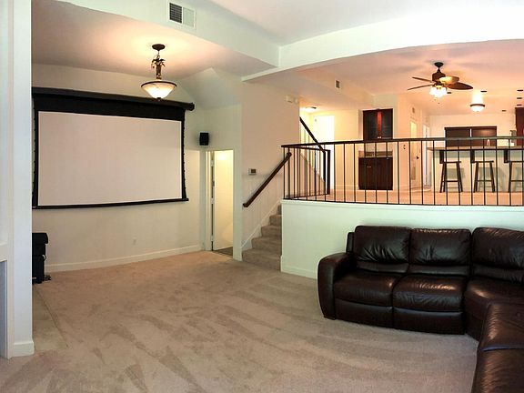 Living Room transforms into a home theater with blackout shades, 119" retractable screen, surround sound, HD projector, and huge wrap-around leather couch!