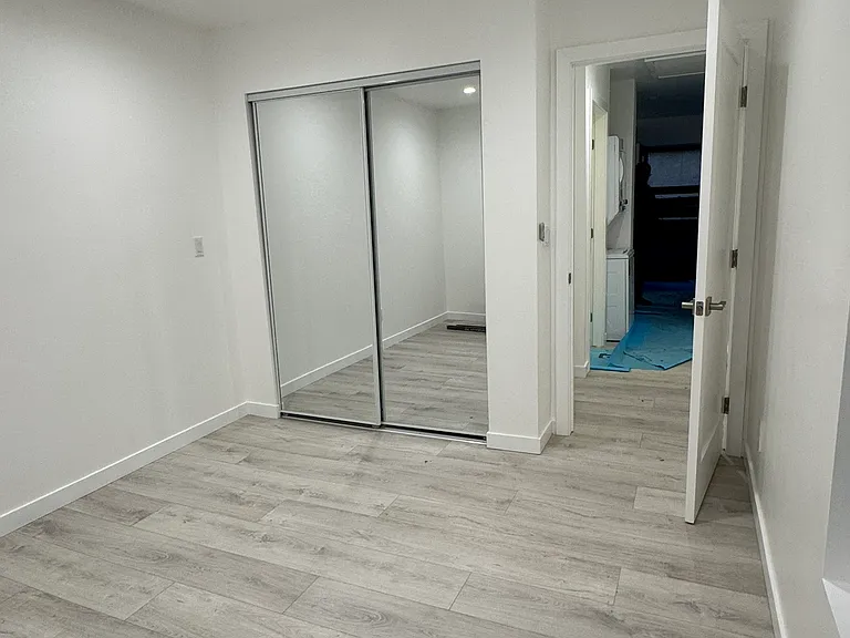 Secondary bedroom with fan and mirrored closet