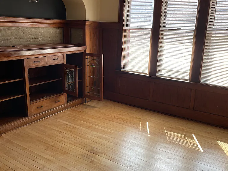 Dining area extended off of living room with original dry bar and built-in unit.