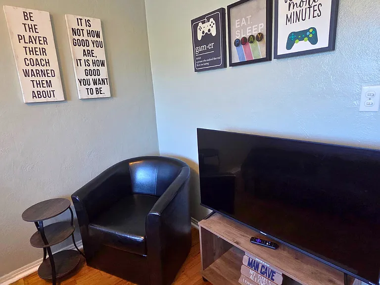 Bedroom with Smart TV, decorative artwork, and cozy accent chair