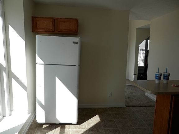 Refrigerator in kitchen and walk through to living areas.