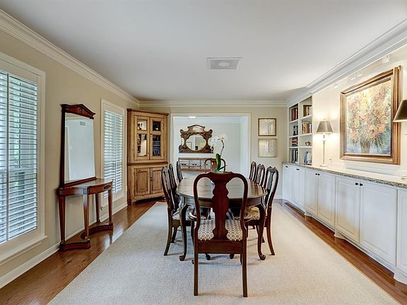 The dining room has a wall of cabinets, bookshelves and an art niche. Two large windows overlook the front yard.