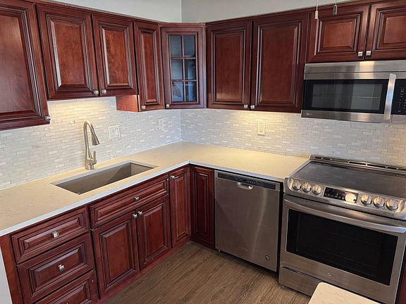 Kitchen with appliances electric stove, microwave, dishwasher, garbage disposal