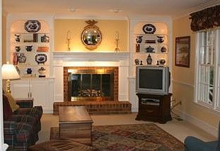 Family Room with custom built-ins on either side of wood burning fireplace
