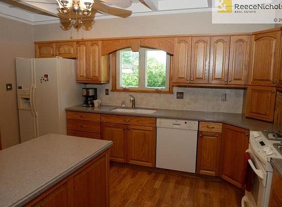 Kitchen with windows over the sink, gas range and the refrigerat