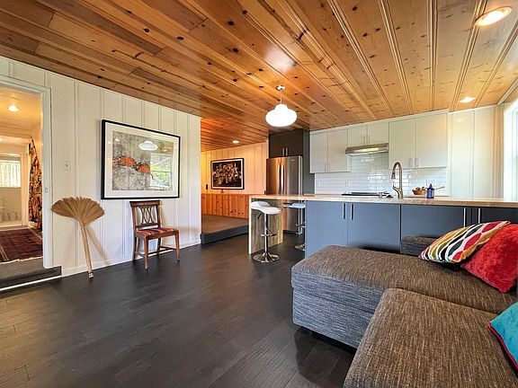 Living Room and newly renovated kitchen with white subway tile backsplash and knotty pine ceilings