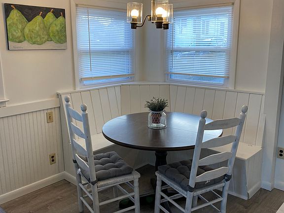Kitchen nook with table and chairs. Bench seat includes seating for 4.