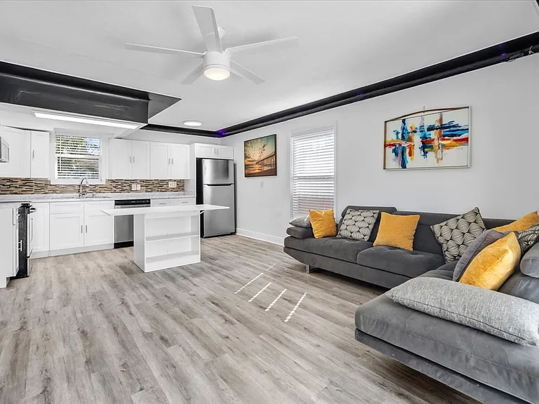 Living room has staged furniture. Does not come with the sofa or island
