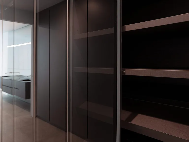 Walk-In Closet with Floor-to-Ceiling Glass Doors _ Designed for both function and elegance, this closet features sleek glass-paneled doors, integrated shelving, and soft-touch storage solutions.