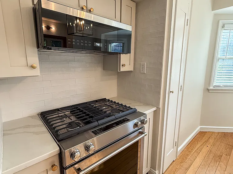 Dual fuel gas stove, electric oven and slim overhead microwave.