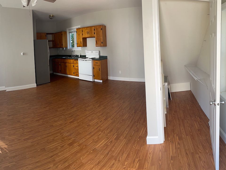 Panoramic view of living room, kitchen, and closet under stairs.