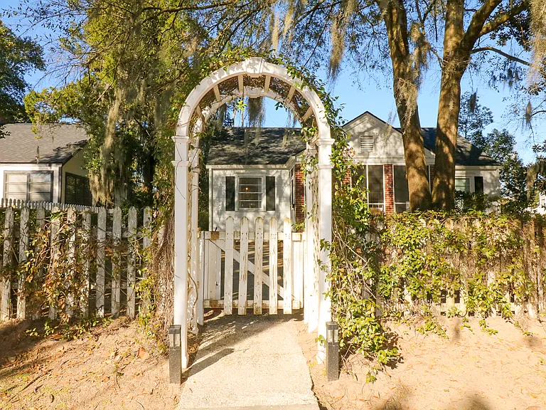 White picket fence offers privacy from the street. Large oak tree in the front yard offers shade and classic Savannah charm