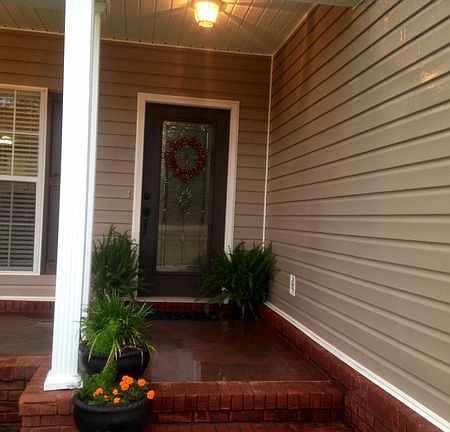 Stained concrete on front and back porch. Newly painted shutters and front door