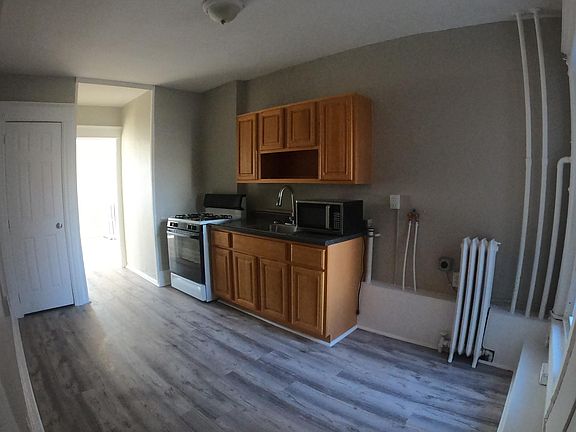 Kitchen - with new flooring, cabinets, sink, and refrigerator; also has washer/dryer hookup and microwave