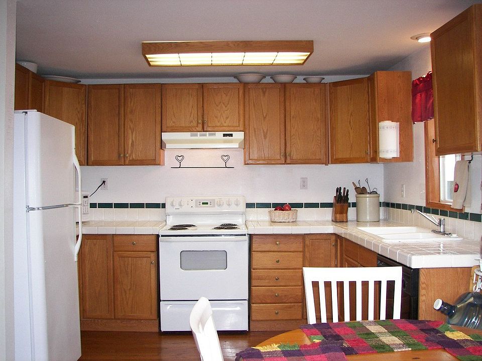 Oak cabinets and floor, dishwasher, tile counters
