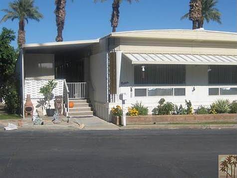 Clean and Landscaped Mobile home features large deck, fenced yard and shed.