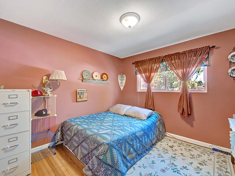 Second bedroom seen from hallway. Windows are on north side of the house, view of fruit trees and cacti.