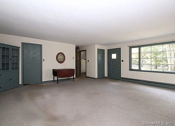 Picture of the living room looking towards the front entrance. Built-in hutch at the left next to the kitchen entrance. There is