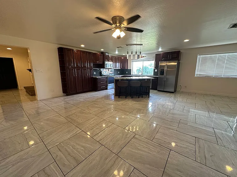 Large kitchen with granite countertops, can lights, tile backsplash, and island sitting area with "waterfall edge"