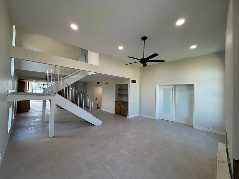 Living Room looking at wetbar on right. Past the stairs is the dining room, kitchen, and dinette.