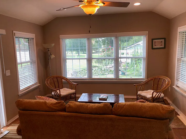Sunroom overlooking backyard pond. Storm shelter entrance is under the area rug near the rear windows.