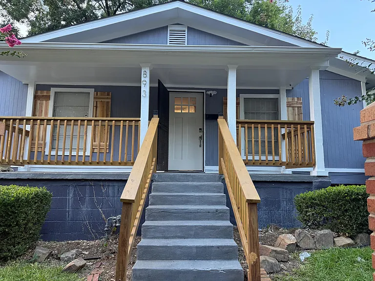 Inviting front porch with covered entry, wide steps, and sturdy railings for easy access and outdoor sitting.