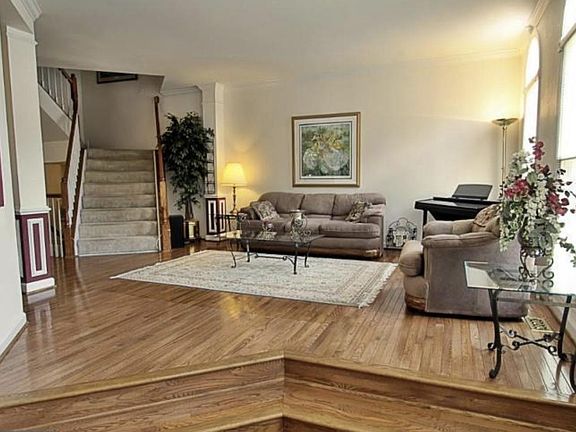 Open floorplan with hardwood floors and sunlight