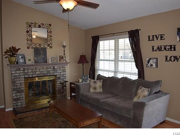 Cozy living room with gas fireplace, hardwood flooring, and beautiful mantle.
