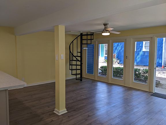 1st floor living area with new laminate flooring, spiral staircase to 2nd floor, and abundant natural light