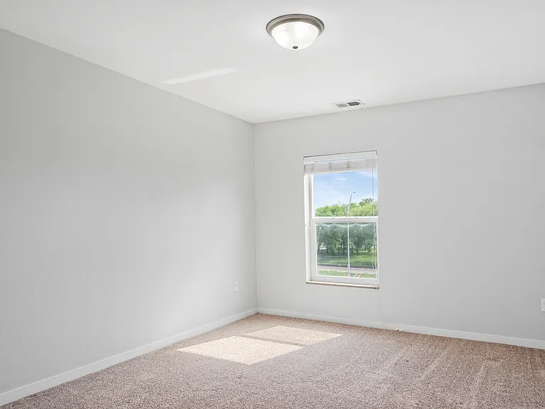 Bright and airy empty room with neutral walls, plush carpet, and large window with a scenic view, perfect for customizing. Bright and airy empty room with neutral walls, plush carpet, and large window with a scenic view, perfect for customizing.