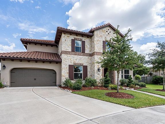 A double wide driveway leads to a 3-car tandem garage, and charming landscape adorns a lush lawn!