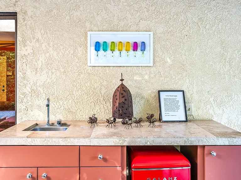 Outdoor wet bar with mini-fridge.